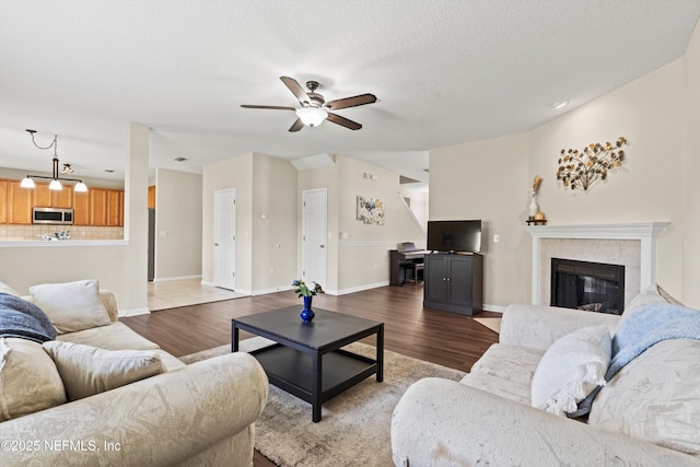 2360 Golfview Dr, Fleming Island, FL 32003 - living room with wood finished floors, ceiling fan, a tiled fireplace, and baseboards