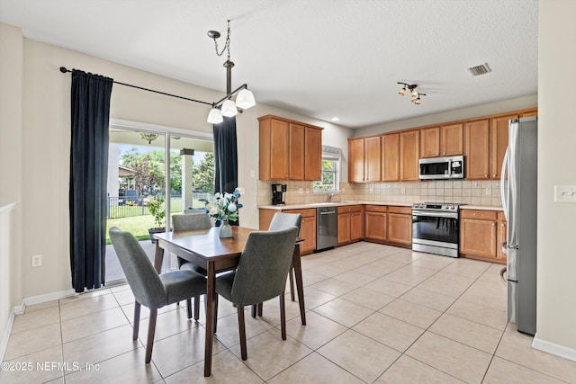 2360 Golfview Dr, Fleming Island, FL 32003 - kitchen featuring appliances with stainless steel finishes, tasteful backsplash, a sink, light tile patterned floors, and a textured ceiling