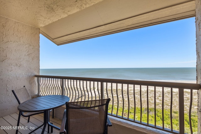 balcony with a water view and a beach view