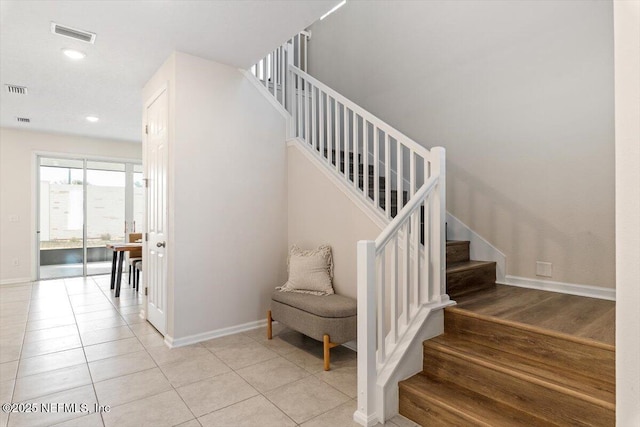 stairway with tile patterned floors