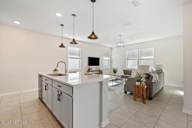 kitchen featuring a kitchen island with sink, sink, decorative light fixtures, and light tile patterned floors