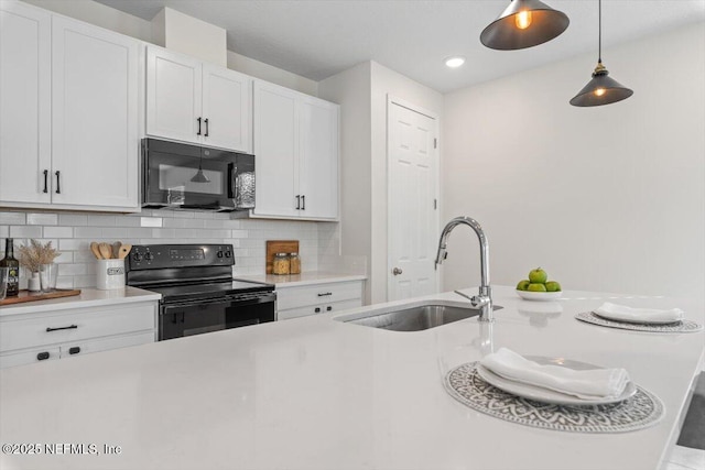 kitchen featuring pendant lighting, white cabinetry, sink, decorative backsplash, and black appliances