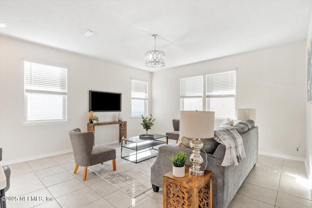 living room featuring light tile patterned flooring and an inviting chandelier