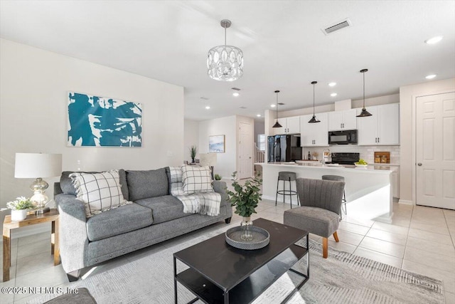 living room featuring light tile patterned flooring and a chandelier