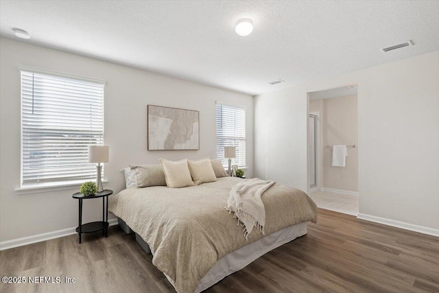 bedroom with dark hardwood / wood-style floors and a textured ceiling