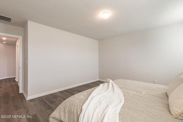 bedroom featuring dark hardwood / wood-style floors and a textured ceiling