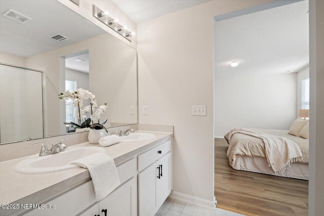 bathroom with vanity, hardwood / wood-style flooring, plenty of natural light, and walk in shower