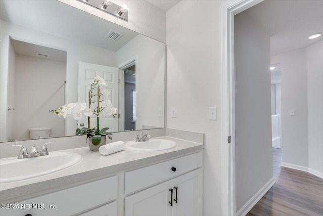 bathroom featuring vanity, hardwood / wood-style floors, and toilet