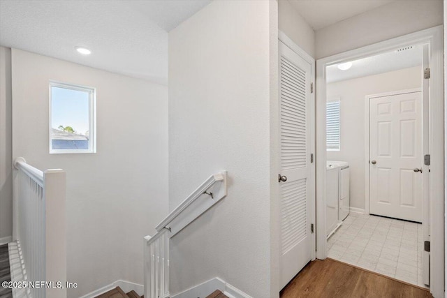 staircase with hardwood / wood-style floors and washer and clothes dryer