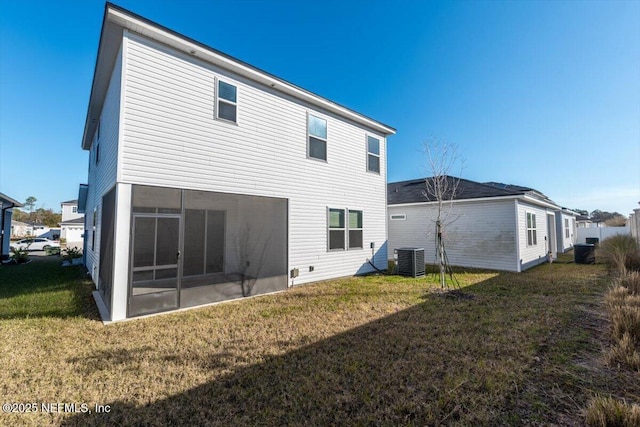 back of property with a sunroom, cooling unit, and a lawn