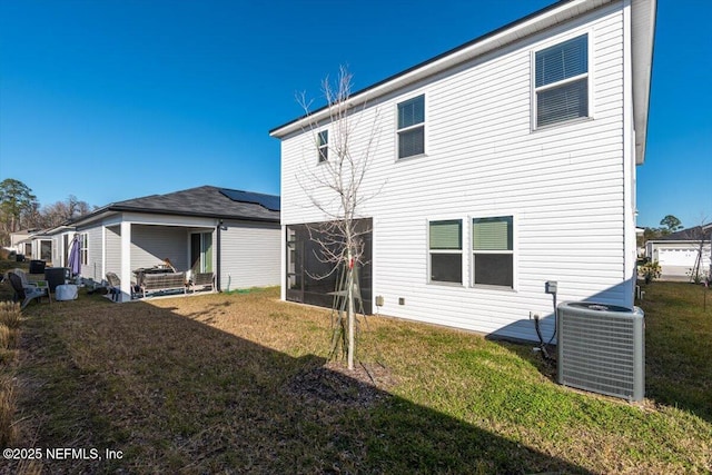 rear view of property featuring a yard and central AC unit