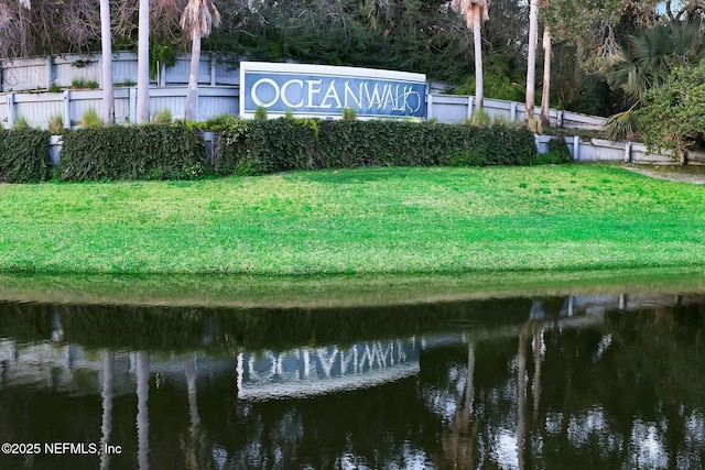 view of home's community featuring a yard, a water view, and fence