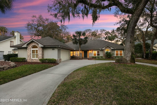 view of front of property with an attached garage, concrete driveway, and a front yard