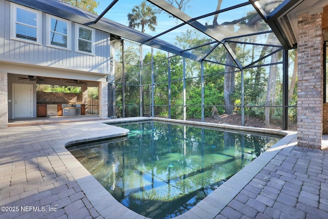 outdoor pool featuring a patio, area for grilling, a lanai, and a ceiling fan