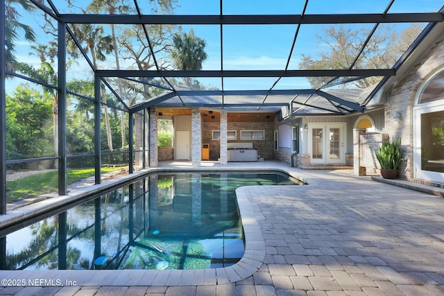 pool featuring a lanai, grilling area, a patio area, and a jacuzzi