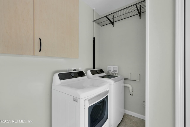 laundry area featuring cabinet space, baseboards, and washer and clothes dryer