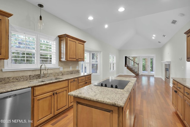 kitchen with visible vents, lofted ceiling, a sink, stainless steel dishwasher, and black electric cooktop