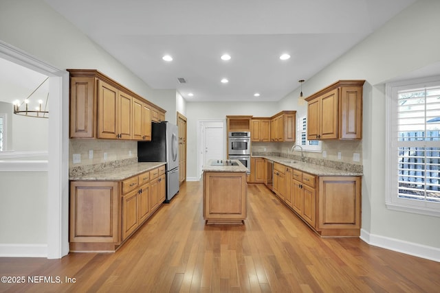 kitchen featuring plenty of natural light, appliances with stainless steel finishes, light wood-style floors, and a sink