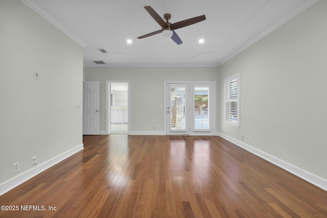 spare room with ornamental molding, baseboards, a ceiling fan, and wood finished floors