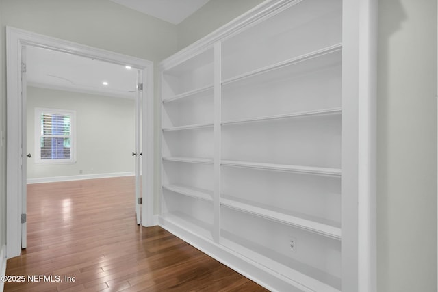 hall with recessed lighting, built in shelves, baseboards, and wood finished floors