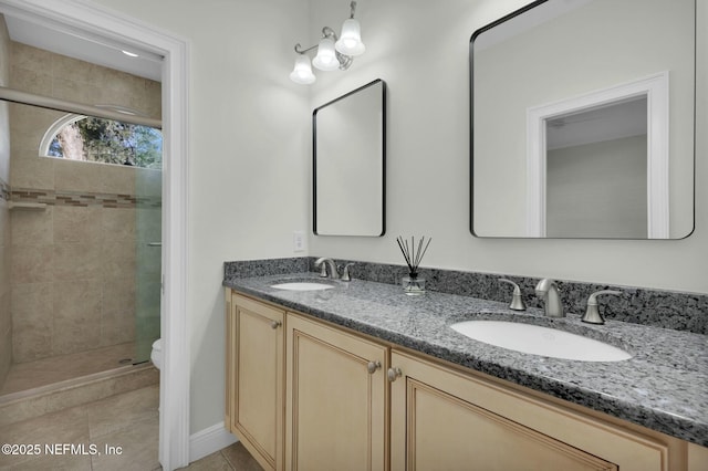 bathroom with a sink, a shower stall, tile patterned floors, and double vanity