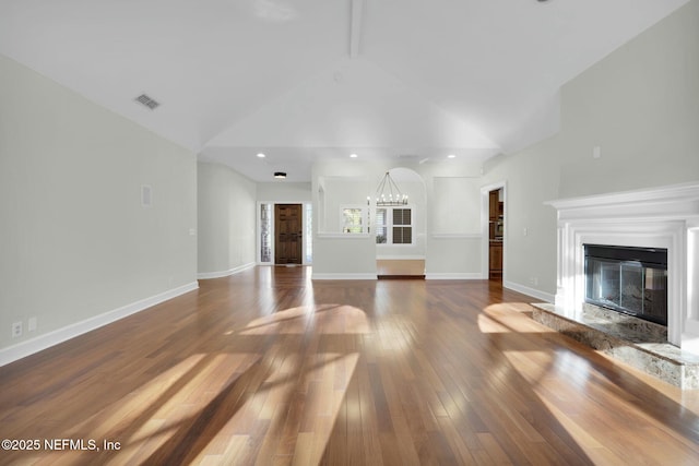 unfurnished living room with a glass covered fireplace, baseboards, wood-type flooring, and high vaulted ceiling