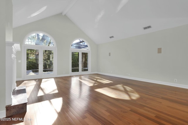 unfurnished living room with visible vents, high vaulted ceiling, beam ceiling, hardwood / wood-style flooring, and french doors