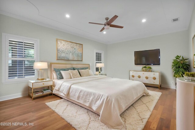 bedroom with baseboards, light wood finished floors, and visible vents