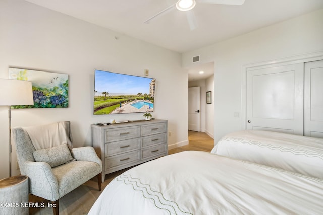 bedroom with light hardwood / wood-style floors, a closet, and ceiling fan