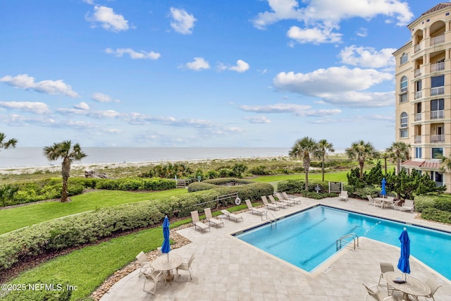 view of pool with a patio and a water view