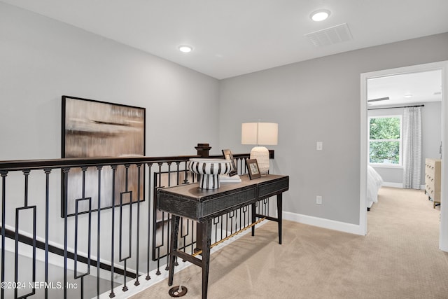 hallway featuring light colored carpet