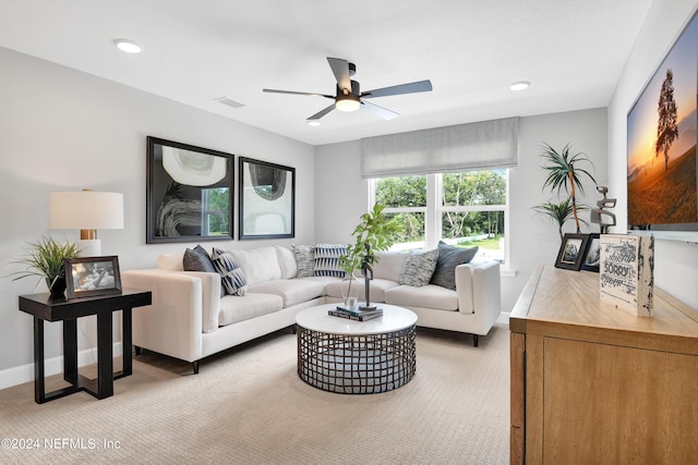 carpeted living room with ceiling fan