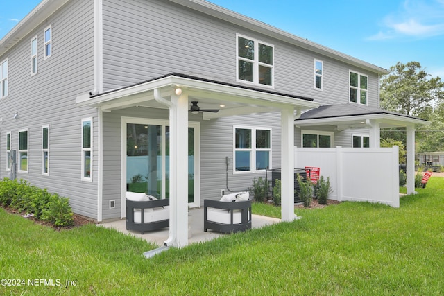 back of property with a lawn, ceiling fan, and a patio area