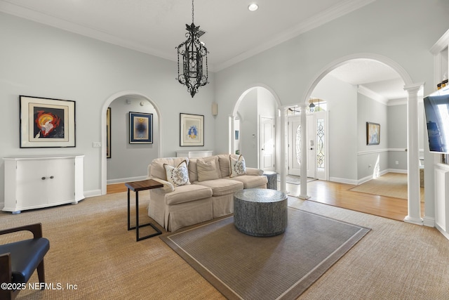 living room featuring decorative columns, crown molding, and light wood-type flooring