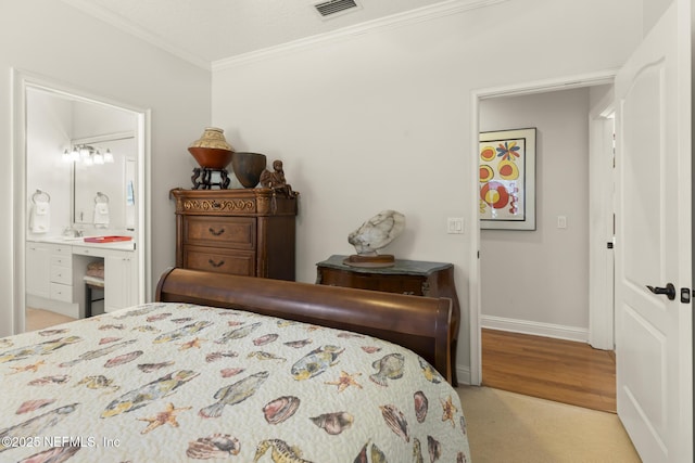 bedroom featuring crown molding, light colored carpet, and ensuite bath