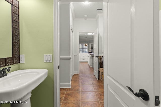 bathroom featuring crown molding, tile patterned floors, and sink