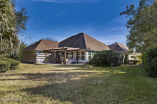 rear view of house featuring a yard and a pergola