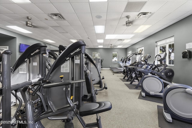 workout area featuring baseboards, visible vents, and a drop ceiling