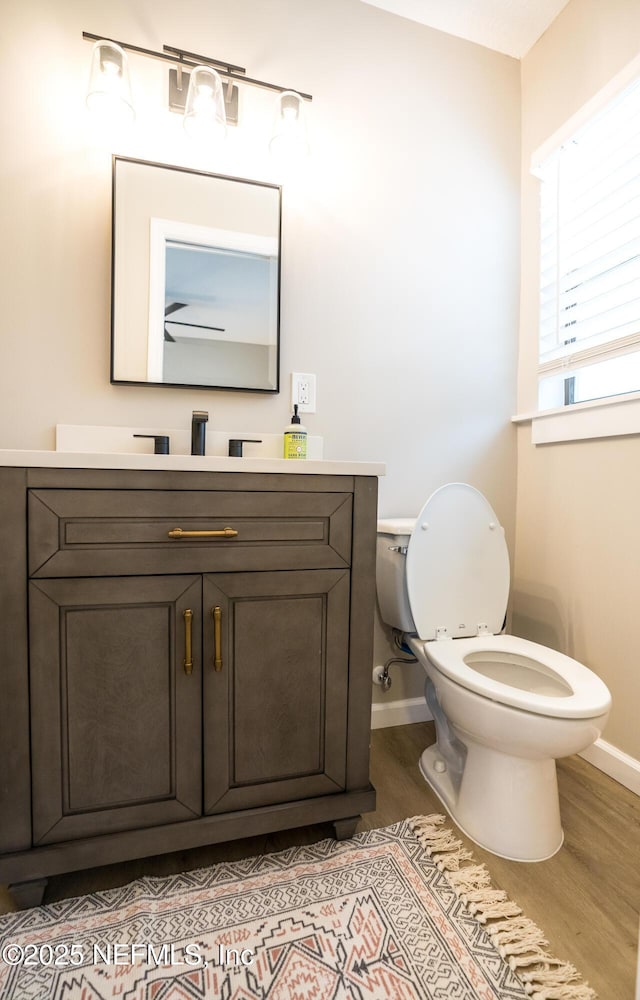 bathroom featuring vanity, hardwood / wood-style floors, and toilet