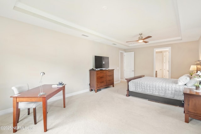 carpeted bedroom featuring ceiling fan and a tray ceiling