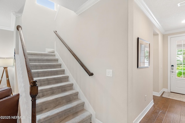 stairs featuring ornamental molding and hardwood / wood-style floors