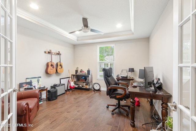 home office featuring hardwood / wood-style flooring, ceiling fan, a raised ceiling, crown molding, and french doors