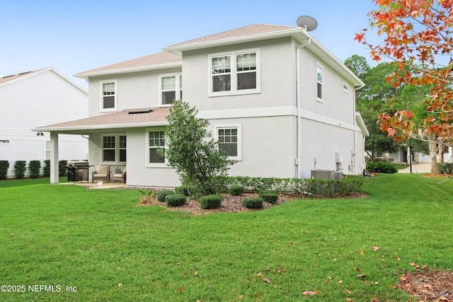 back of property with cooling unit, a yard, and a patio area