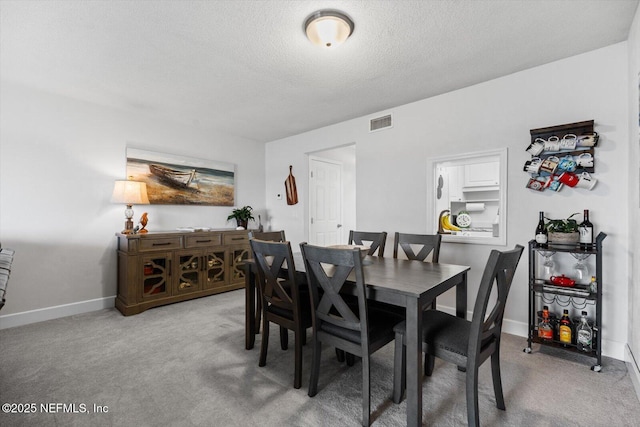 dining area featuring carpet floors and a textured ceiling