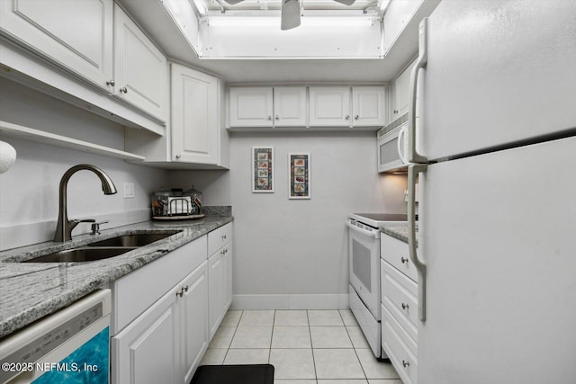 kitchen featuring sink, white cabinetry, light tile patterned floors, white appliances, and light stone countertops