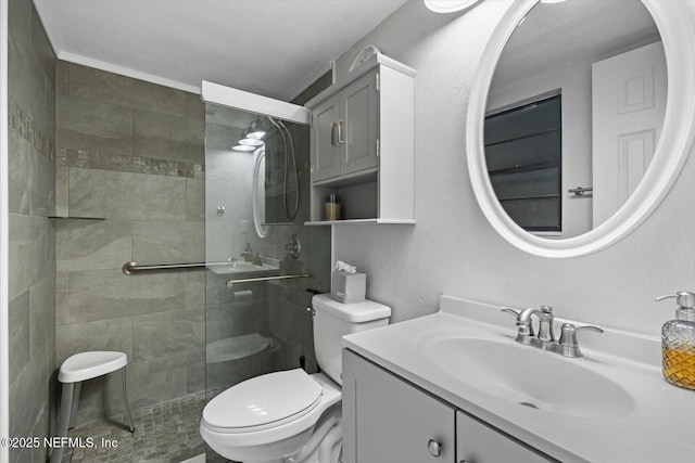 bathroom featuring a tile shower, vanity, and toilet