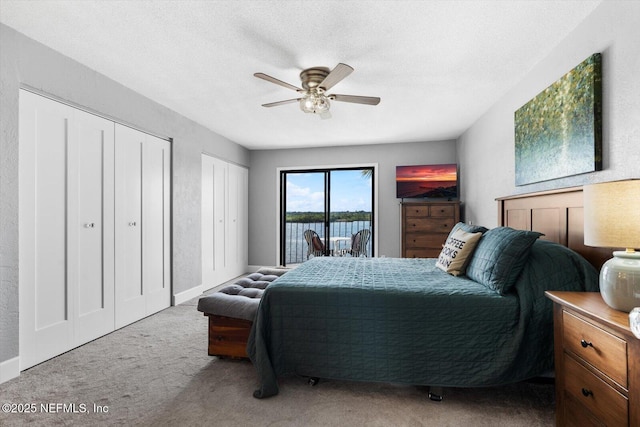 bedroom featuring ceiling fan, two closets, light carpet, and access to outside