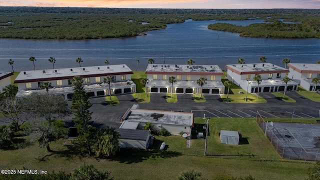 aerial view at dusk featuring a water view