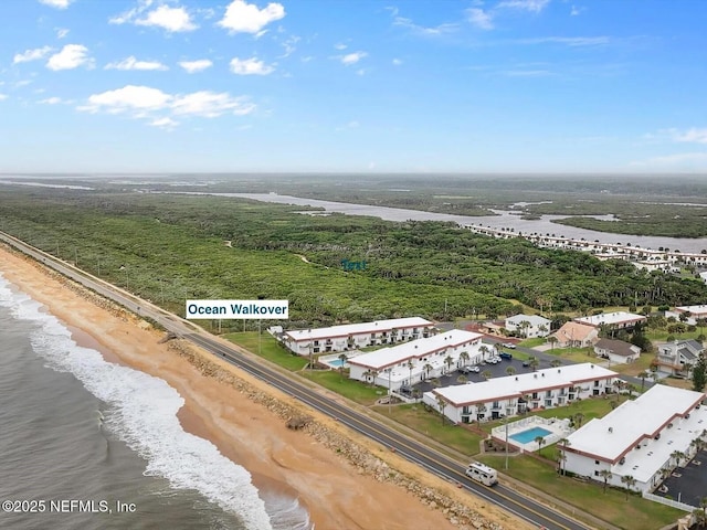 drone / aerial view with a water view and a beach view