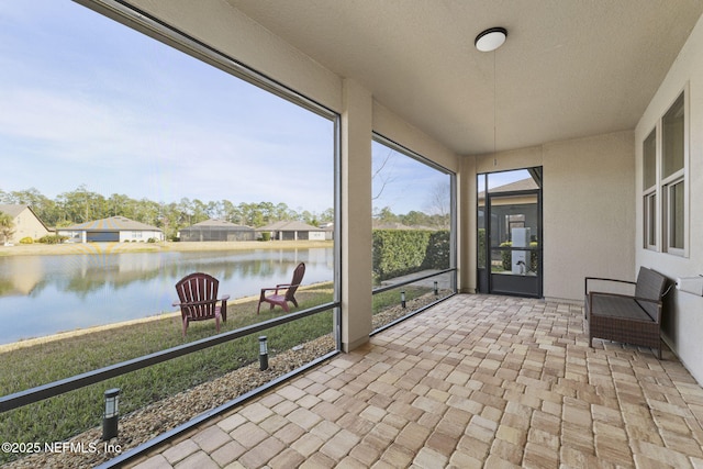 unfurnished sunroom featuring a water view